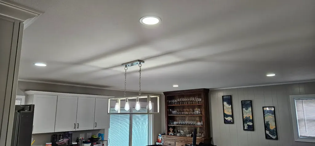 Kitchen ceiling with new recessed can lights and a modern pendant fixture